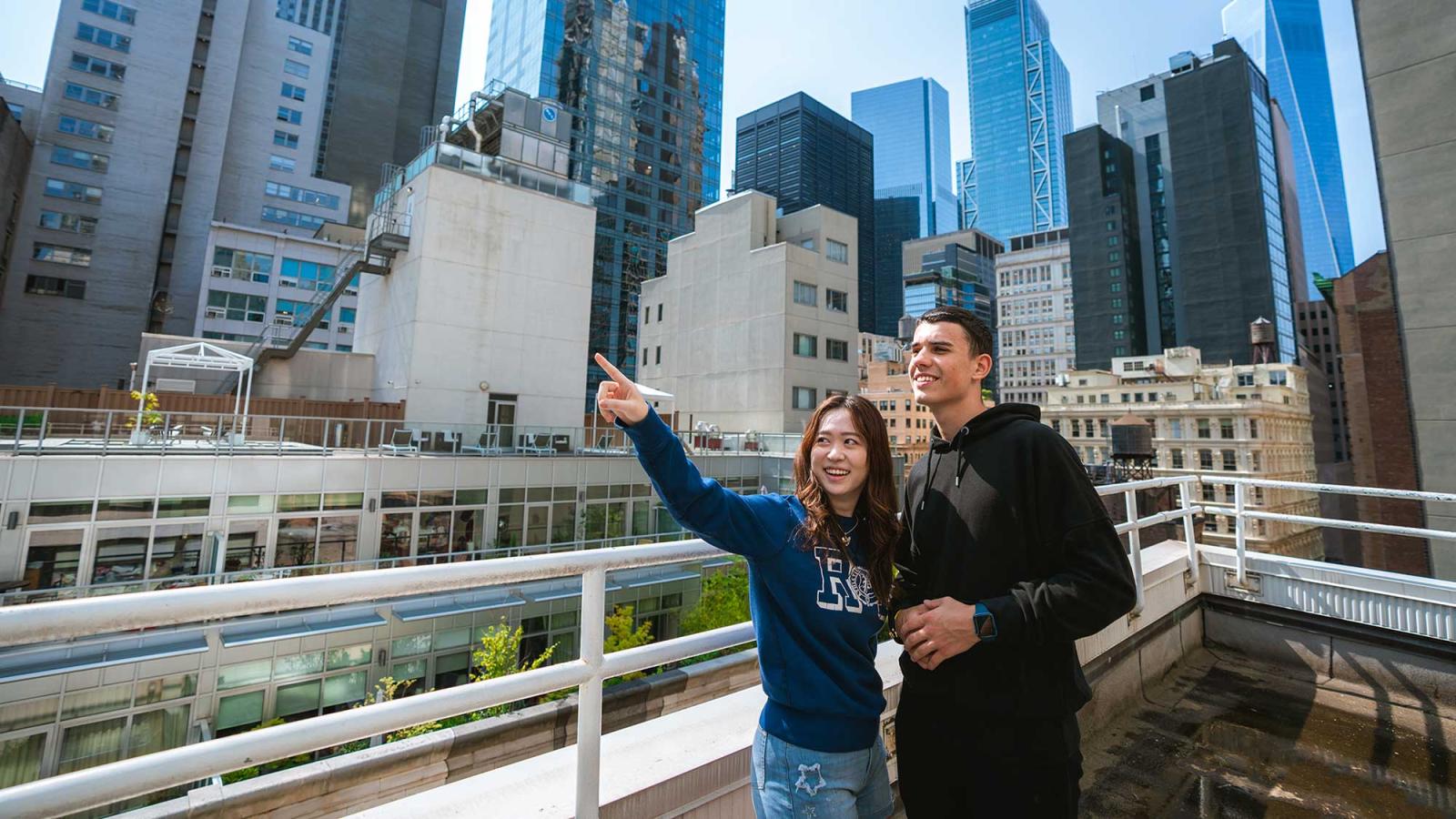 两个学生在阳台上俯瞰曼哈顿市中心